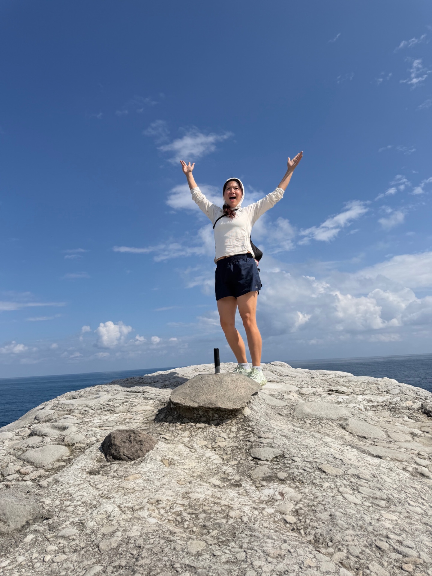 Guest cheering on a wind-carved cliff above the ocean