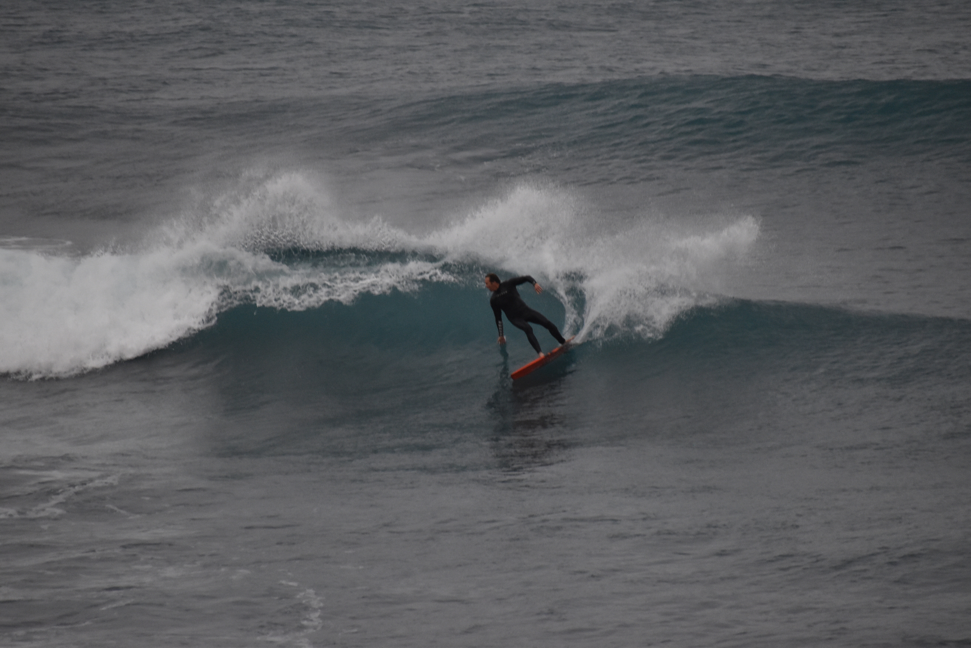 Surfer trimming down the face of a clean East Coast wave