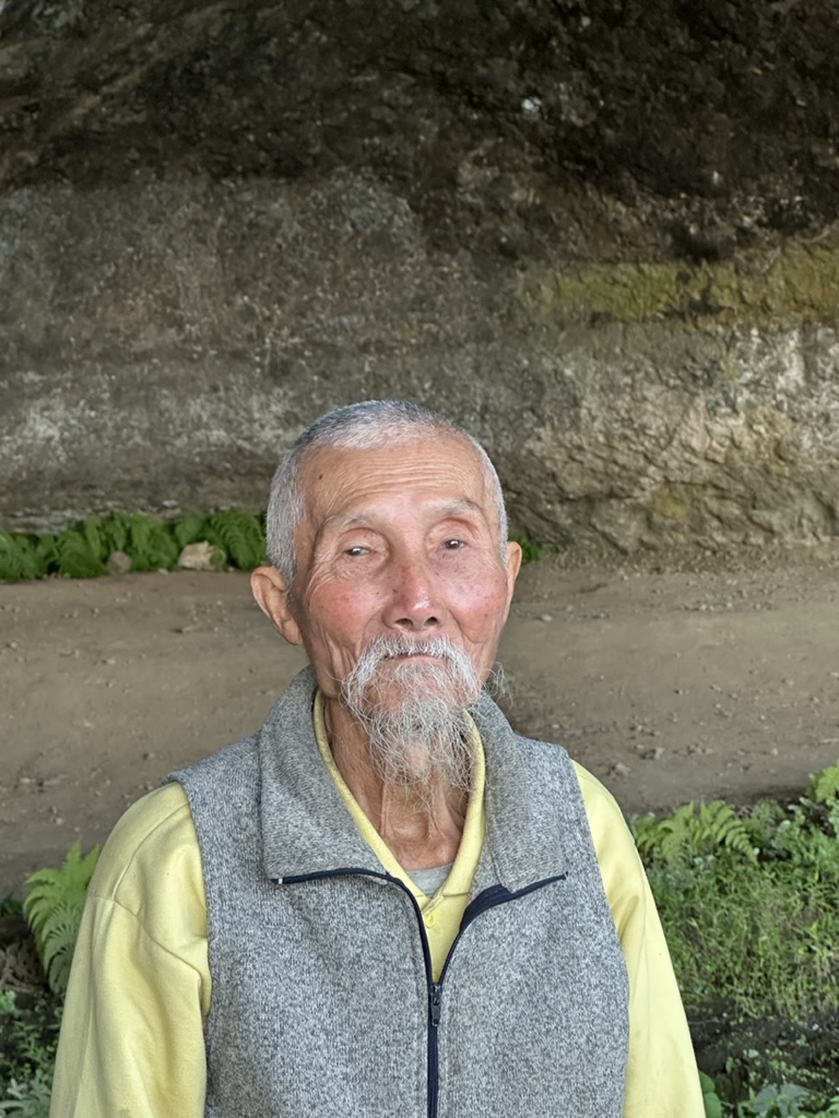 Portrait of a local elder outside a cave shelter
