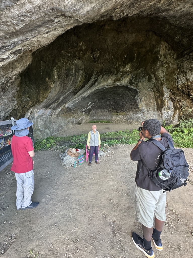 Meeting a local elder at the mouth of a coastal cave