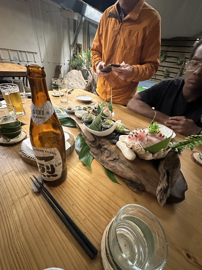 Sashimi platter served on driftwood with a local classic beer