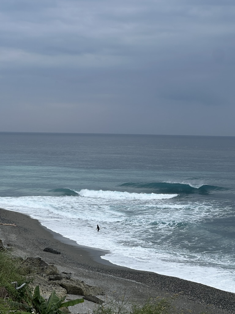 Surfer walking out through the shorebreak