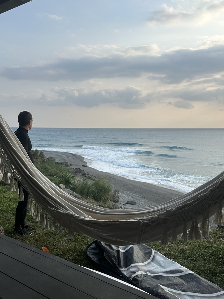 Hammock view of the beach with a surfer watching the swell