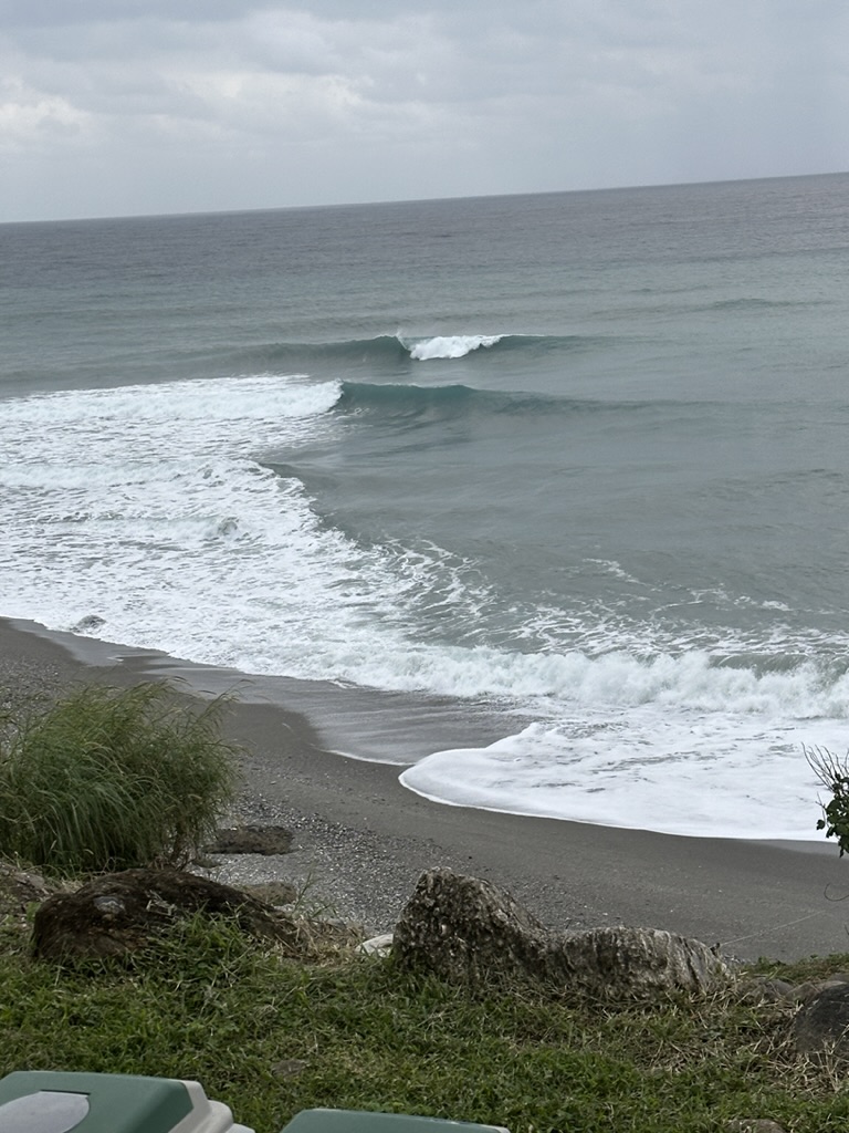 Grey-water peak folding onto a pebble beach