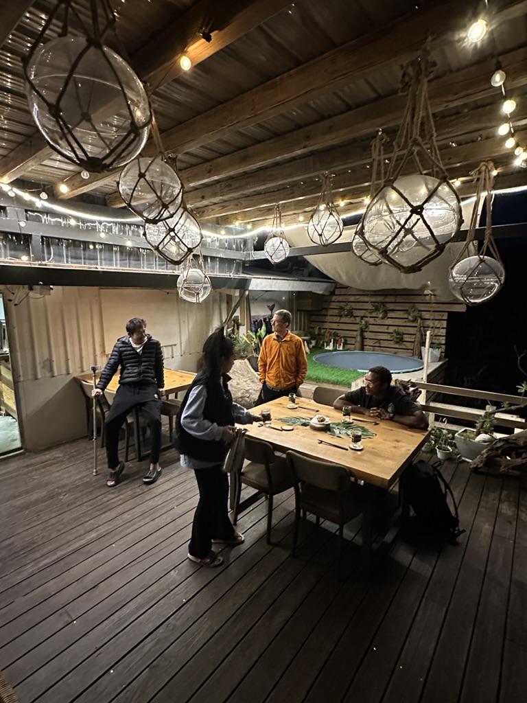 Deck dinner under glass-float lanterns after dark